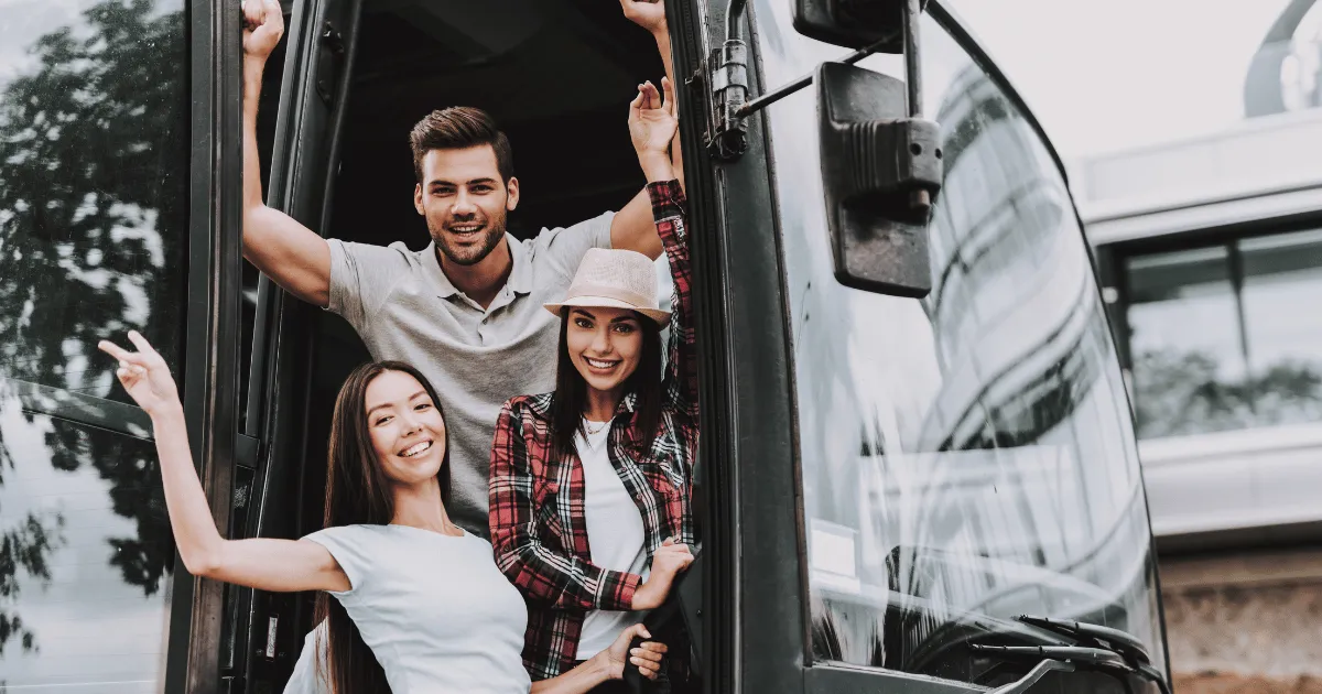 Friends waving from the door of a party bus
