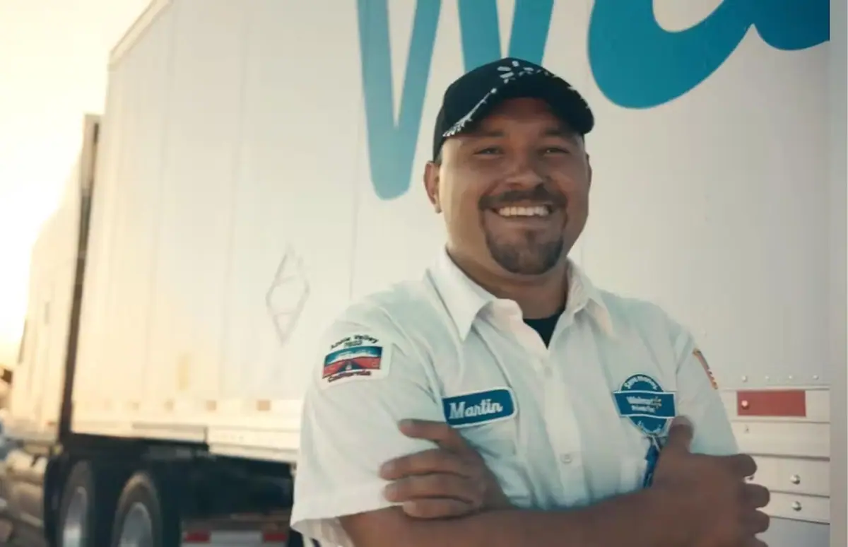 Smiling Walmart driver in front of a truck