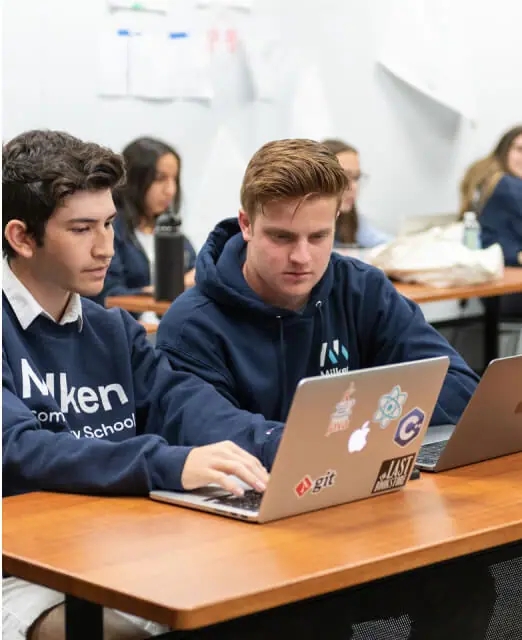 Students working on laptops in a classroom