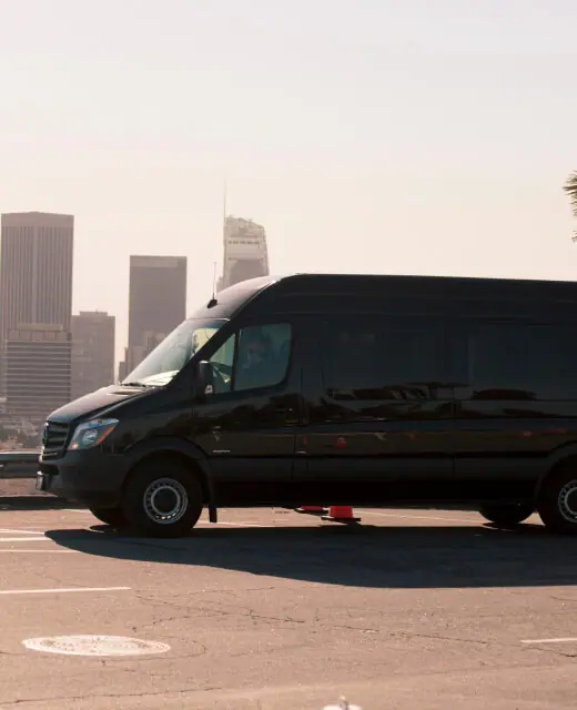 Black Sprinter van in front of the Los Angeles skyline