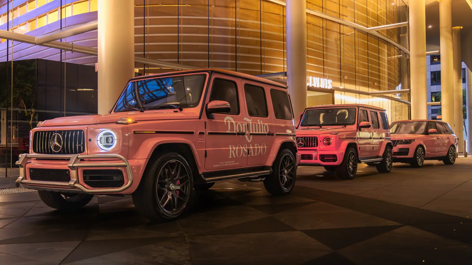 Pink Don Julio branded G-Class vehicles outside a hotel at night