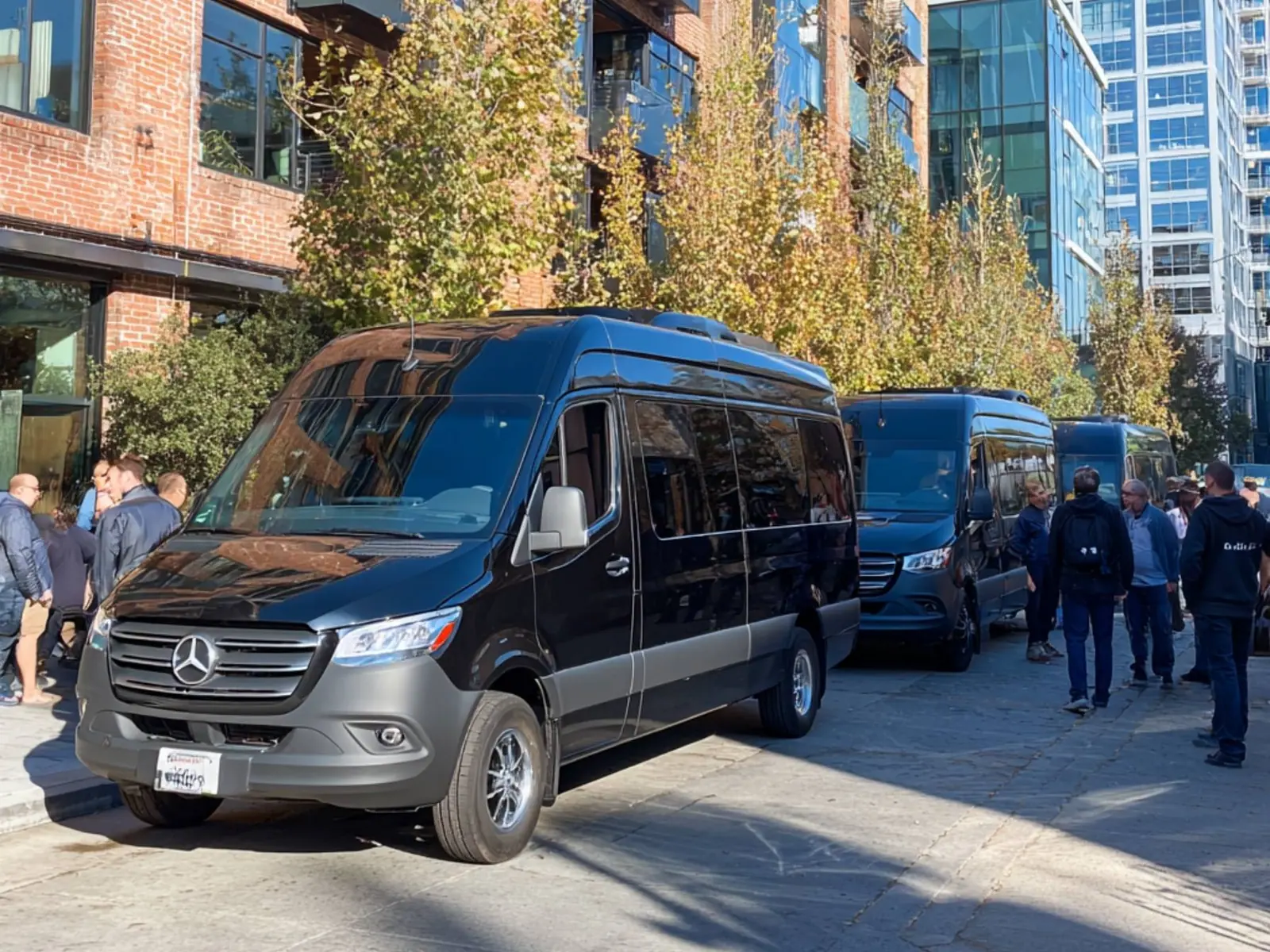Black Sprinter vans lined up on a city street