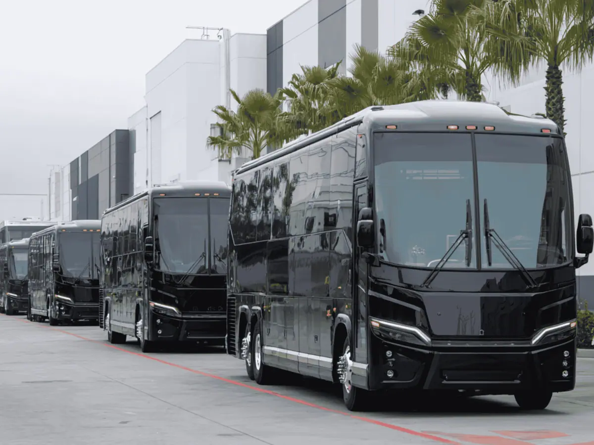 Black coach buses lined up outside an office building