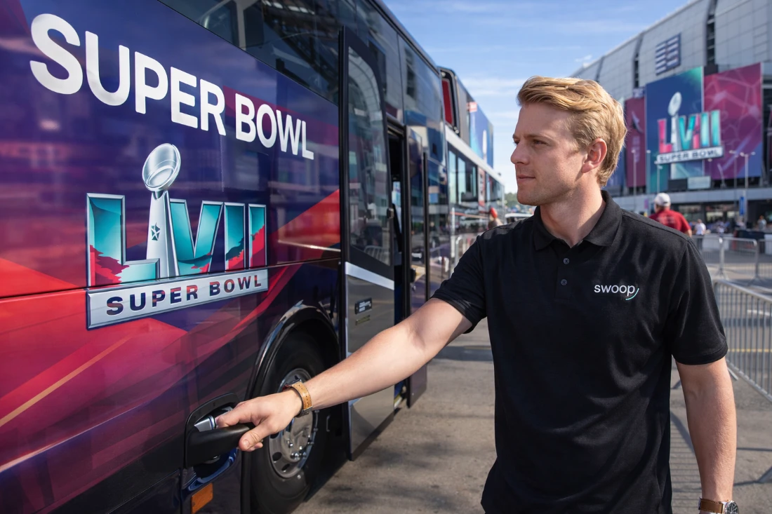 Swoop team member next to a Super Bowl LVII wrapped bus
